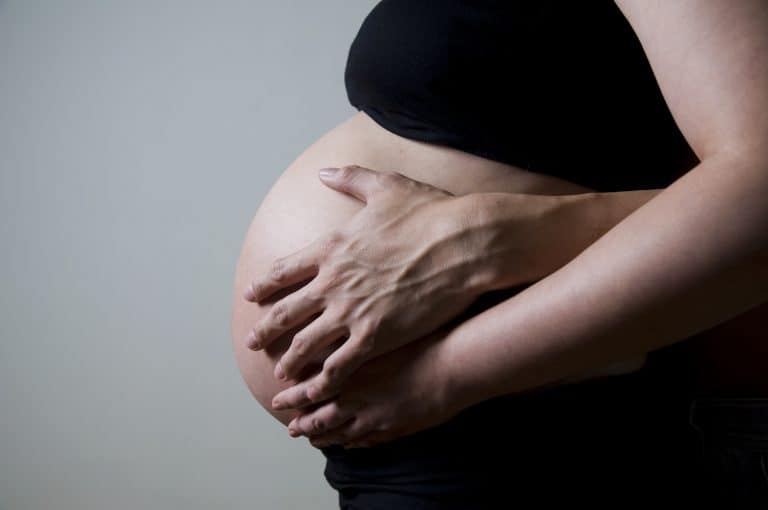Mann und Frau greifen auf Babybauch